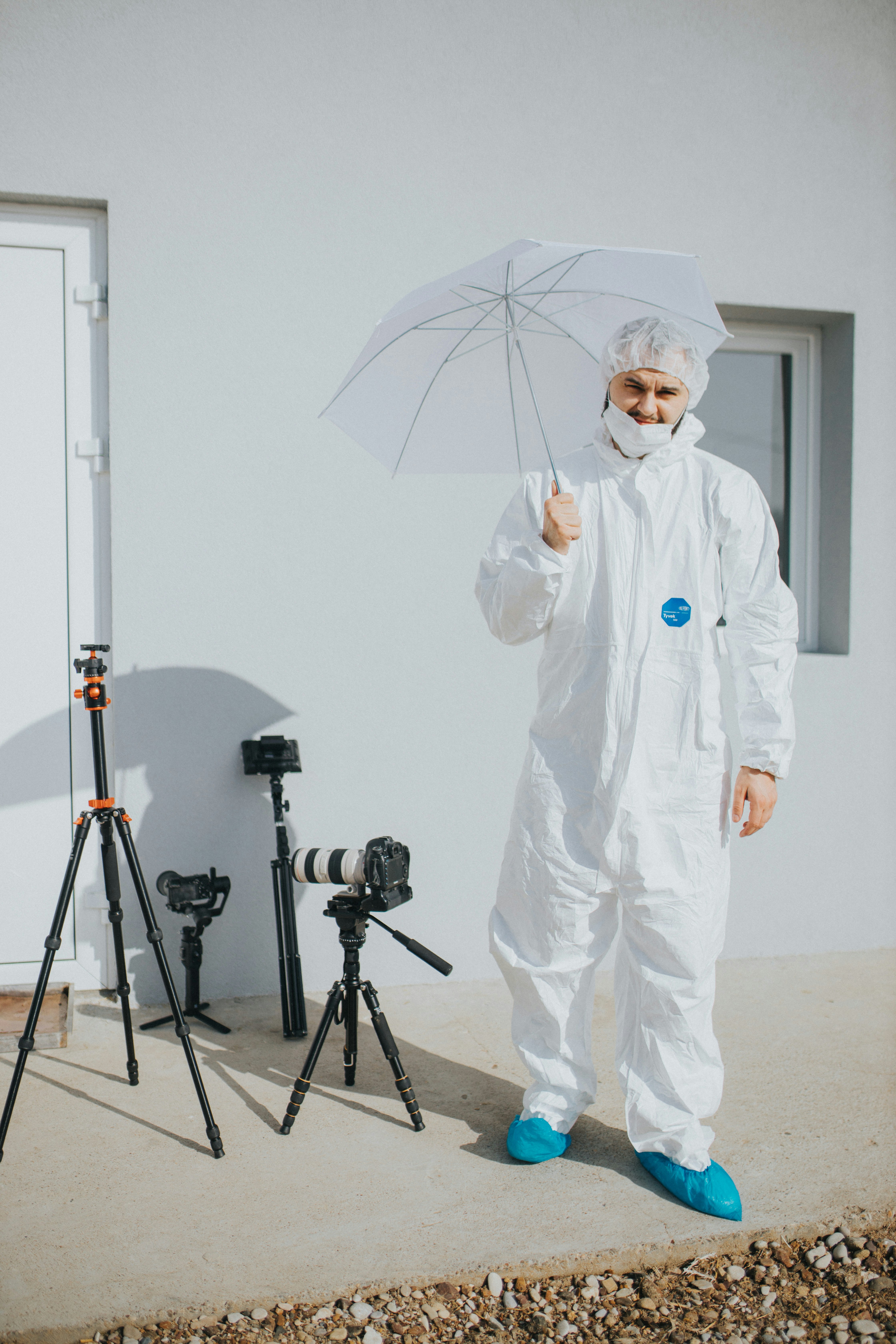 man in white robe holding umbrella